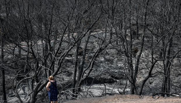 Una mujer observa, este sábado uno de agosto, los efectos causados por el incendio en una zona cercana a la localidad de Artana (Castellón)