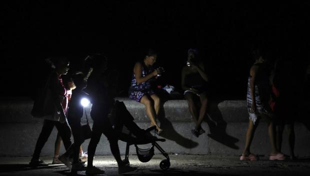 Personas caminan durante un apagón este sábado, en La Habana (Cuba)