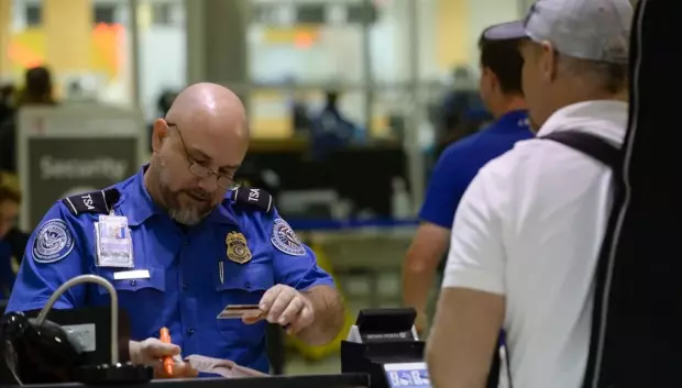 Un oficial observando la documentación de un pasajero, en el aeropuerto internacional Hartsfield-Jackson de Atlanta
