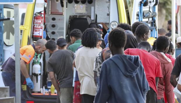 Inmigrantes hacen fila para ser atendidas por los servicios médicos este martes, en la playa El Trampolín de Ceuta