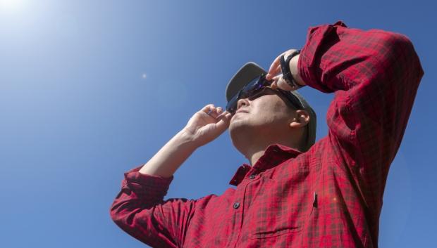 Un hombre observa un eclipse con sus gafas