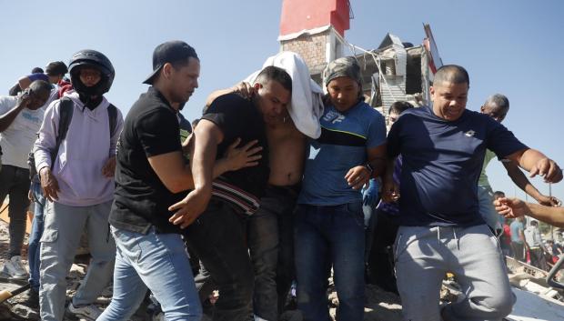 Personas son evacuadas de un edificio colapsado este lunes, en Cali (Colombia). Al menos 20 edificios sufrieron graves daños por consecuencia del terremoto