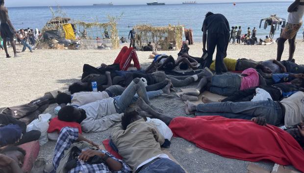 CEUTA, 09/08/2026.- Numerosos inmigrantes permanecen en la playa del Trampolín que se ha transformado en un asentamiento desde la entrada masiva registrada a finales de julio en la ciudad Ceuta.  EFE/Reduan