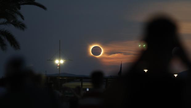La corona solar resplandece mientras la Luna oculta totalmente el Sol durante la fase de totalidad del eclipse solar total, visto desde la playa del Arenal en Llucmajor, en Mallorca.