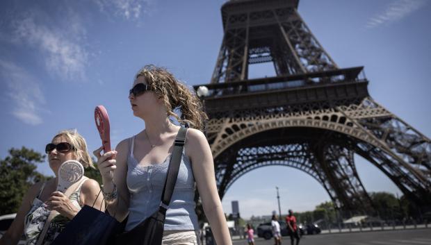 Unas mujeres utilizan ventiladores eléctricos para refrescarse durante una ola de calor en París