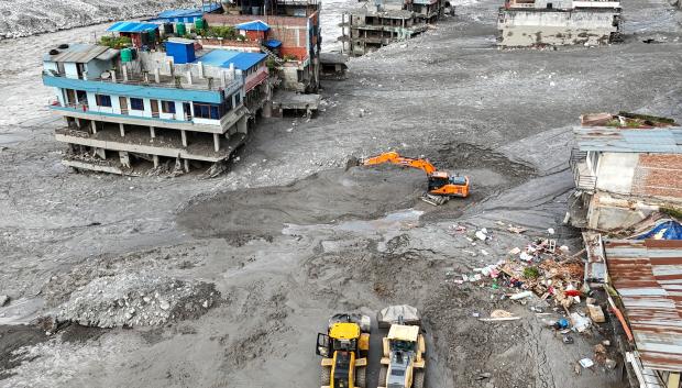 Una vista aérea muestra a trabajadores utilizando excavadoras para retirar el lodo tras las inundaciones repentinas en Trishuli, en el distrito nepalí de Nuwakot