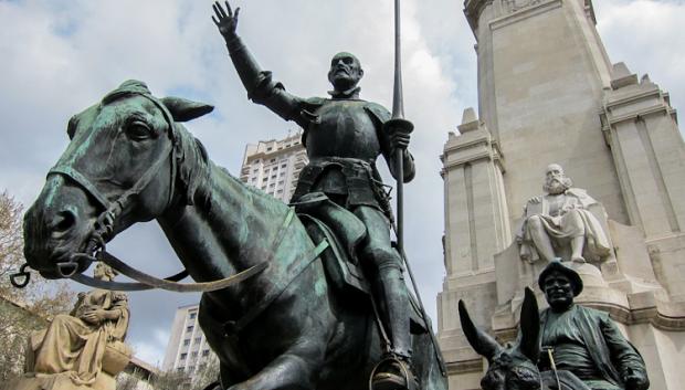 Cervantes está representado tras Quijote y Sancho, sentado y sosteniendo un libro