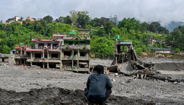 Un hombre observa casas dañadas tras unas inundaciones repentinas en el centro de Trishuli, en el distrito nepalí de Nuwako