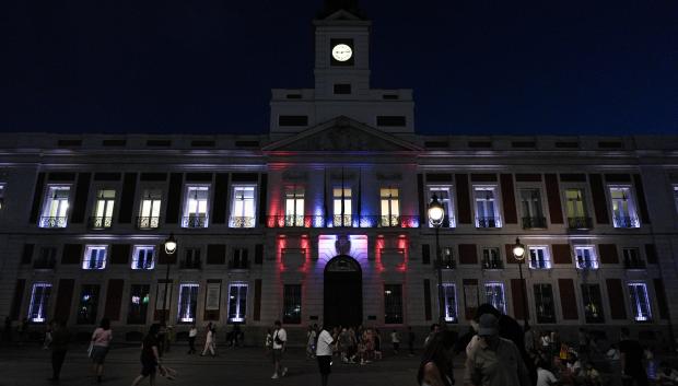 La fachada de la Real Casa de Correos iluminada con la bandera de Ceuta.