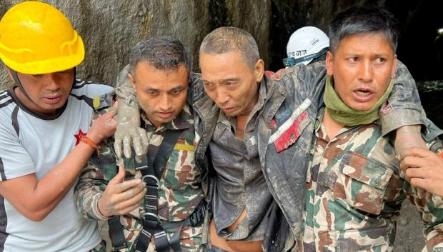 Rescatistas trasladan a un ciudadano chino rescatado de una central hidroeléctrica afectada por un deslizamiento de tierra