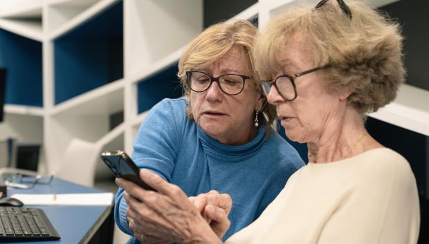 Dos personas mayores participantes en un taller de competencias digitales