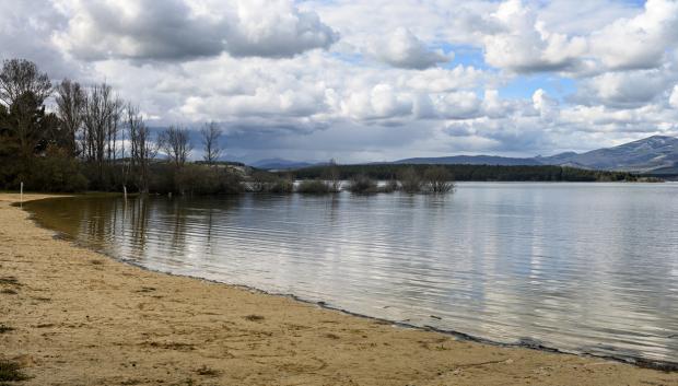 Las tranquilas aguas del embalse de Aguilar reflejan las nubes y las lejanas colinas