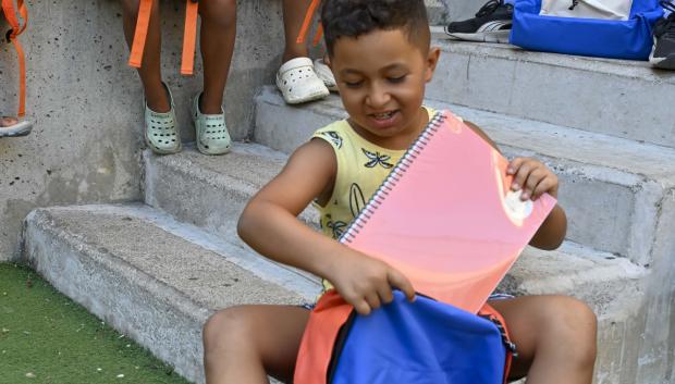 Un niño usuario del programa CaixaProinfancia con material escolar nuevo