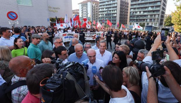 Jorge Buxadé con los medios y los radicales detrás con pancartas