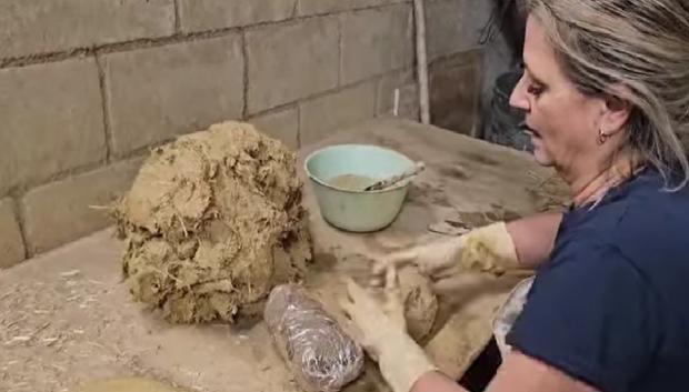 Toñi, esposa de Juan, moldeando con arcilla de Huelva y paja los cencerros para llevarlos al horno