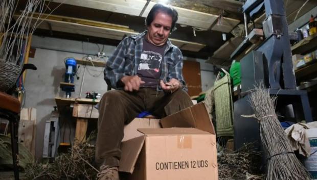 Francisco fabricando un canasto en su taller con varas de olivo