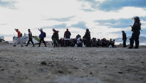 Un grupo de inmigrantes que ocupaban la explanada del Guano en Ceuta siendo desalojados por la Policía Nacional