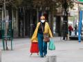 Una mujer camina después de hacer la compra (Madrid)