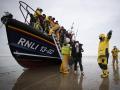 Un grupo de inmigrantes es ayudado a desembarcar por un bote salvavidas RNLI (Royal National Lifeboat Institution) en una playa en Dungeness en la costa sureste de Inglaterra el 16 de diciembre de 2021