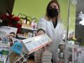 Una farmaceútica muestra el último test de antígenos que tiene disponible a la venta en su farmacia de Madrid