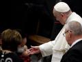 Francisco con un niño en la audiencia general en el aula Pablo VI