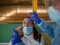 Un trabajador sanitario realiza un test de antígenos a una mujer durante el cribado poblacional celebrado en Ribadavia, en Ourense, este jueves