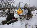 Un soldado ucraniano posa flores sobre su bandera