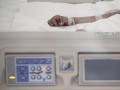 Mano de un enfermo con vía subcutánea en una cama de la UCI del Hospital de Emergencias Isabel Zendal, Madrid