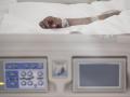 Mano de un enfermo con vía subcutánea en una cama de la UCI del Hospital de Emergencias Isabel Zendal, Madrid