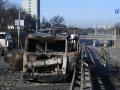 Soldados ucranianos pasan junto a un vehículo del ejército ucraniano quemado en el lado oeste de la capital ucraniana de Kiev.