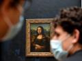 Dos personas llevan mascarillas en el Museo del Louvre