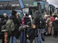 Un grupo de refugiados hace cola para subir a un autobús en la frontera entre Polonia y Ucrania, este martes