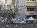 Un soldado ucraniano vigila el entorno de un bloque de apartamentos bombardeado en Kiev, este jueves