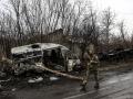 Un soldado ucraniano patrulla junto a un vehículo quemado en el pueblo de Lukianivka, cerca de Kiev