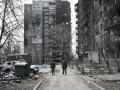 Dos soldados caminan entre edificios destruidos por los ataques rusos en Mariúpol