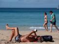 Numerosos turistas disfrutan del sol y el buen tiempo en la playa de Morro Jable, en Fuerteventura