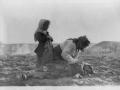 Una mujer armenia arrodillada junto a un niño muerto en el campo