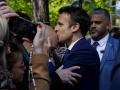 El presidente de Francia y candidato presidencial del partido LREM, Emmanuel Macron, besa a un partidario cuando llega a votar en un colegio electoral en Le Touque