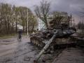 Un hombre monta en bicicleta junto a un tanque destruido en la ciudad ucraniana de Chernígov, el 21 de abril