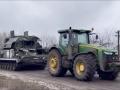 Ukrainian agricultural tractor pulling a Russian army tank