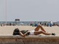 Una joven toma el sol en el paseo marítimo de la playa de La Malvarrosa (Valencia), este sábado