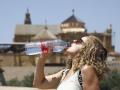 Una turista bebe agua para combatir el calor, en Córdoba, ante las altas temperaturas que registra la Península por la ola de calor