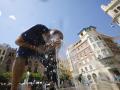 Un hombre se refresca para aliviar el calor en una fuente del centro de Córdoba