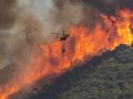 Un helicóptero trabaja en la extinción del incendio del paraje El Higuerón de Mijas