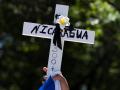 Un manifestante sostiene una cruz en protesta contra la represión a la Iglesia en Nicaragua