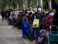 Largas colas de gente para pedir comida en barrio de Aluche, en Madrid