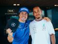 Fernando Alonso recoge la gorra firmada por Hamilton