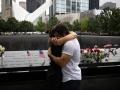 Dos personas se abrazan frente al memorial a las víctimas del 11-S en el lugar donde se levantaban las torres gemelas de Nueva York