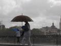 Dos personas caminan bajo sus paraguas en Sevilla, este martes