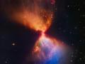El telescopio espacial James Webb reveló su última imagen de la majestuosidad celestial el miércoles, un reloj de arena etéreo de polvo naranja y azul que sale disparado de una estrella recién formada en su centro